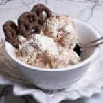 A bowl of No Churn Chocolate Pretzel Caramel Ice Cream shows the ice cream and a few chocolate pretzels.