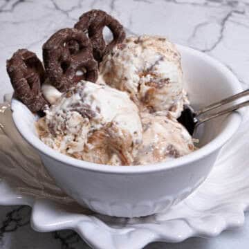 A bowl of No Churn Chocolate Pretzel Caramel Ice Cream shows the ice cream and a few chocolate pretzels.
